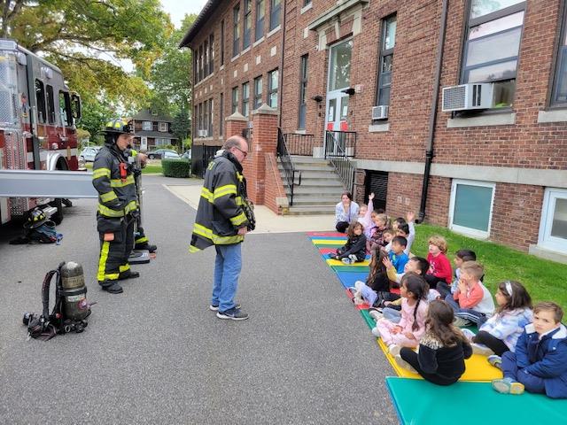 firefighter with kids on mats